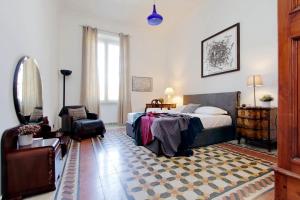 ein Schlafzimmer mit einem Bett und einem Stuhl in der Unterkunft 4BNB - Tiberina Spacious Apartment in Rom