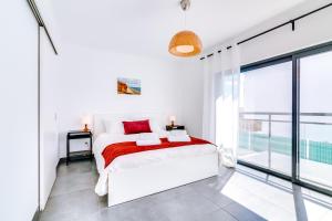Dormitorio blanco con cama y ventana grande en SEA VIEW LARANJEIRAS, en Quelfes