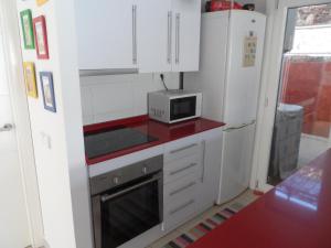 małą kuchnię z białymi szafkami i kuchenką mikrofalową w obiekcie Apartamento encantador w mieście Las Negras