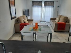 una sala de estar con una mesa y un sofá en Puerto de la duquesa beach apartment, en Castillo de Sabinillas