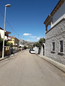 una calle vacía en un pueblo con un edificio de piedra en Casa Mene', en Arzachena