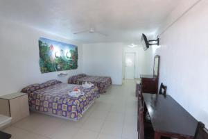 a hotel room with two beds and a painting on the wall at Posada Real in Rincon de Guayabitos