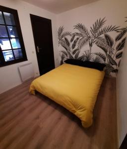 ein Schlafzimmer mit einem gelben Bett und einem Gemälde an der Wand in der Unterkunft La Balagne ça nous gagne in Algajola