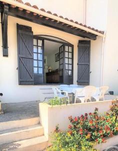 een patio met een tafel en stoelen in een huis bij La Balagne ça nous gagne in Algajola