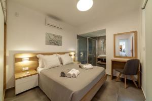 1 dormitorio con 1 cama con silla y espejo en Merelia Luxury Villas - Halkidiki, en Nea Moudania