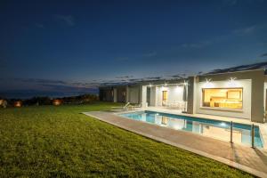 ein Haus mit Swimmingpool bei Nacht in der Unterkunft Merelia Luxury Villas - Halkidiki in Nea Moudania