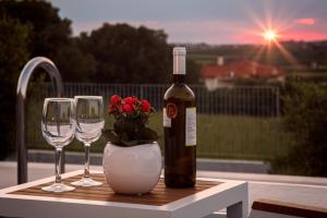 eine Flasche Wein und zwei Weingläser auf einem Tisch in der Unterkunft Merelia Luxury Villas - Halkidiki in Nea Moudania + 50 Fotos
