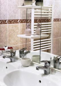 a bathroom sink with two faucets and a mirror at Villa Marguerite in Coutras