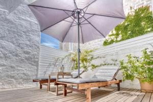 a patio with an umbrella and a bench at Can Alberti 1740 Boutique Hotel in Mahón