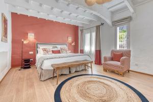 a bedroom with a large bed and a chair at Can Alberti 1740 Boutique Hotel in Mahón