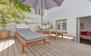 a patio with a table and an umbrella at Can Alberti 1740 Boutique Hotel in Mahón