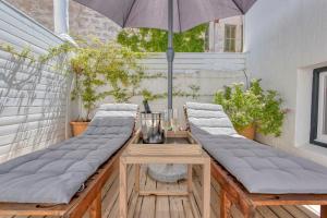 a row of benches on a patio with an umbrella at Can Alberti 1740 Boutique Hotel in Mahón