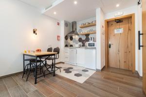 a kitchen with a table and chairs and a counter at Roots Hotel in Faro