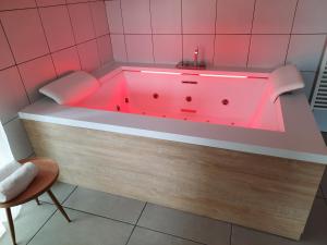a bath tub with a red light in a bathroom at La Tour d'Olympe in Recoules-Prévinquières