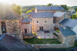 eine Luftansicht auf ein großes Steinhaus mit Hof in der Unterkunft La Tour d'Olympe in Recoules-Prévinquières