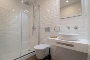 a bathroom with a toilet and a sink and a shower at Roots Hotel in Faro