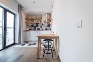 a kitchen with a wooden table and a counter at Roots Hotel in Faro