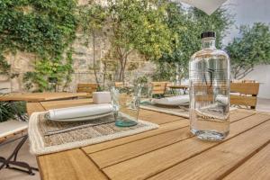 a bottle of water sitting on top of a wooden table at Can Alberti 1740 Boutique Hotel in Mahón
