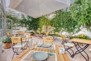 an outdoor patio with tables and chairs and trees at Can Alberti 1740 Boutique Hotel in Mahón