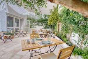 a patio with a wooden table and chairs at Can Alberti 1740 Boutique Hotel in Mahón