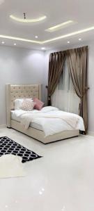 1 dormitorio con 1 cama y una ventana con cortinas en مساكن الدار 8, en Abha
