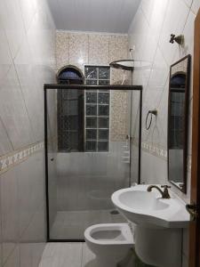 a bathroom with a shower and a toilet and a sink at Pousada Enseada de Bertioga in Bertioga