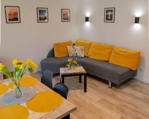 a living room with a couch and a table at Apartament SŁONECZNY Pięć mórz Sianożęty in Sianozety