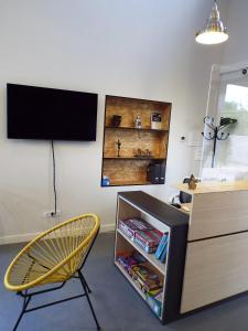 a room with a tv and a chair and a desk at Albergue Santiago 15 Monforte in Monforte de Lemos