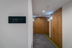 a hallway with wooden doors and a sign on the wall at Roots Hotel in Faro