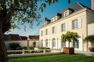 una vista exterior de una gran casa con una valla blanca en Les Chambres du Champagne Collery en Ay