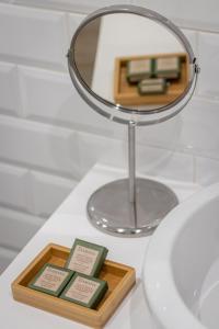 a mirror and a tray of soap on a bathroom sink at Roots Hotel in Faro