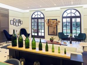 a bunch of wine bottles on a table in a room at Les Chambres du Champagne Collery in Ay