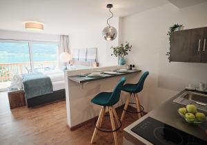 une cuisine avec deux chaises et une cuisine avec un lit dans l'établissement SEE Moment Appartements ADULTS ONLY, à Sankt Wolfgang im Salzkammergut