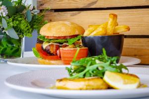 a sandwich and french fries on plates on a table at The Lensbury Resort in Richmond upon Thames