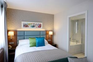 a bedroom with a bed and a bath tub at The Lensbury Resort in Richmond upon Thames