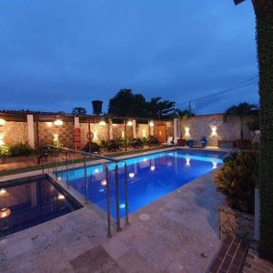 una piscina en un patio trasero por la noche en Hotel Malibu, en San Juan Nepomuceno