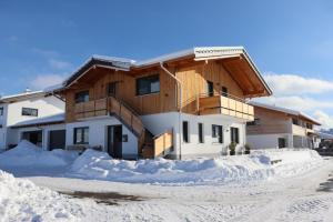 una casa con nieve delante en Ferienwohnung Breyer Wiedemen, en Hopferau