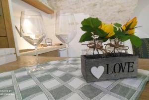 twee wijnglazen en een plant op een tafel bij La Volta del Conte-Holiday Home Centro Storico in Cisternino