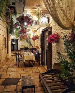 een vrouw aan een tafel in een restaurant bij La Volta del Conte-Holiday Home Centro Storico in Cisternino