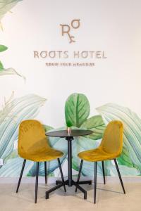 two chairs and a table in front of a wall at Roots Hotel in Faro