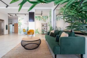 a living room with a green couch and a table at Roots Hotel in Faro