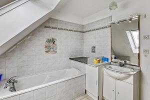 a bathroom with a bath tub and a sink at Maison de 4 chambres avec jardin clos a Nevez a 1 km de la plage in Névez