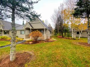 une maison avec une cour arborée devant elle dans l'établissement F9 Fairway Village home on the Mt Washington golf course - in the heart of Bretton Woods, à Carroll