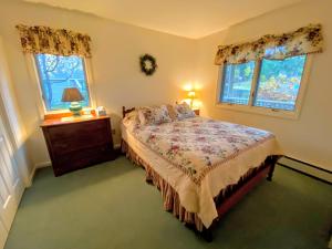 a bedroom with a bed and a dresser and two windows at F9 Fairway Village home on the Mt Washington golf course - in the heart of Bretton Woods in Carroll +30 photos