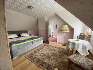 Schlafzimmer im Dachgeschoss mit einem Bett und einem Tisch in der Unterkunft Ferienhaus Marianne in Schwielowsee