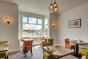 a restaurant with tables and chairs and a window at Palm Court in Skegness