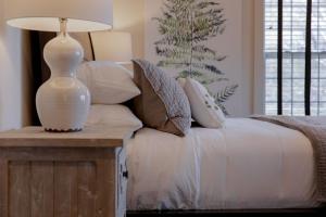 a white lamp sitting on a table next to a bed at The Blowing Rock Manor in Blowing Rock