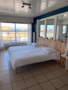 a bedroom with a bed and a large window at Hotel Bord A Bord in Noirmoutier-en-l'lle