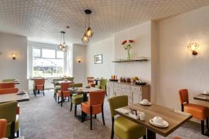 a restaurant with tables and chairs in a room at Palm Court in Skegness
