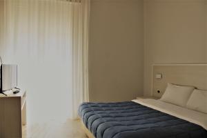 a bedroom with a bed with a blue blanket at Zibibbo Beach Apartments - Trapani in Trapani